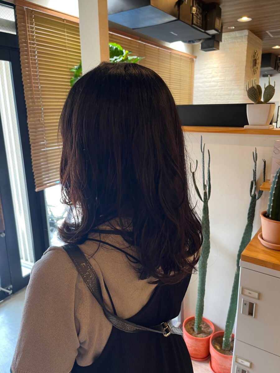 ダークブラウンのミディアムヘアに緩やかな波巻きデジタルパーマを施したスタイル